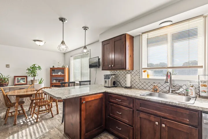 Kitchen featuring dark wood-finish cabinetry, light-toned countertops, and a patterned tile backsplash