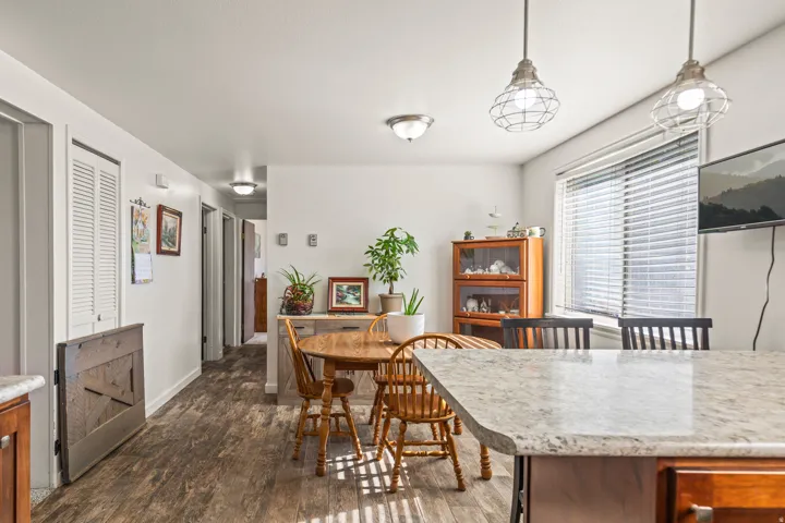 Spacious kitchen island with a stone countertop, wood-finish flooring, and recessed lighting