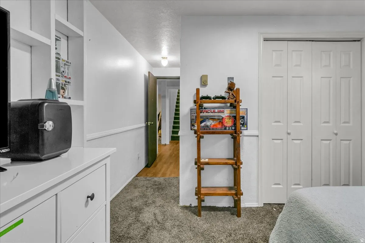 White built-in shelving, white bi-fold closet doors, and wood-finish flooring