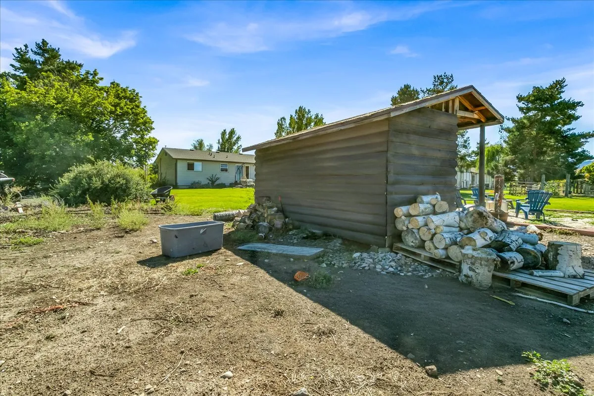 Outdoor storage shed with an open-sided lean-to structure