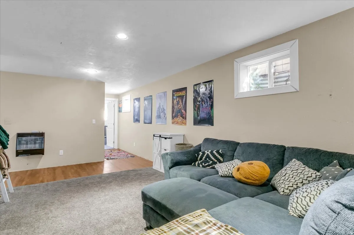 Recessed ceiling lighting, wall-mounted heating unit, wood-finish flooring, and a low-profile window