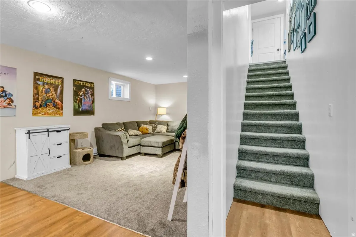 Carpeted recreation room with recessed lighting, a window, and a built-in cabinetry