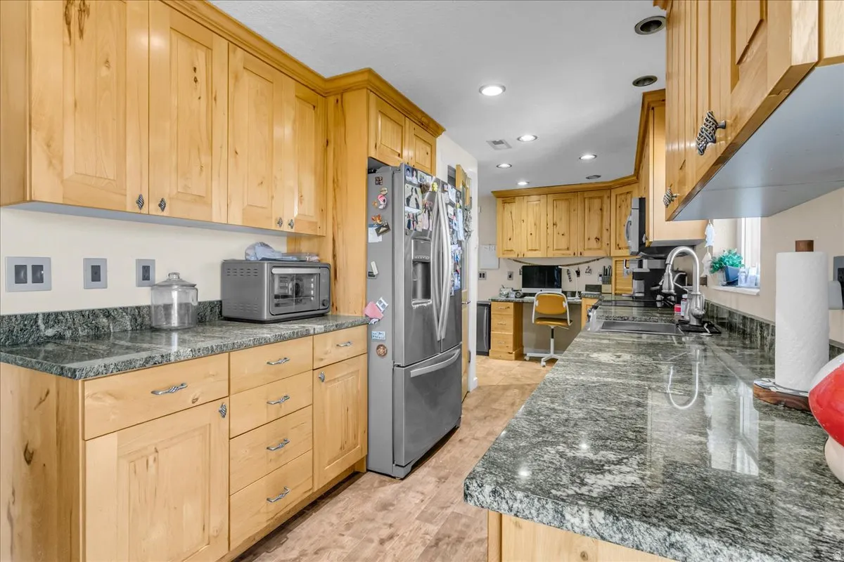 Wood-finish cabinetry and flooring complement the stone countertops throughout this kitchen