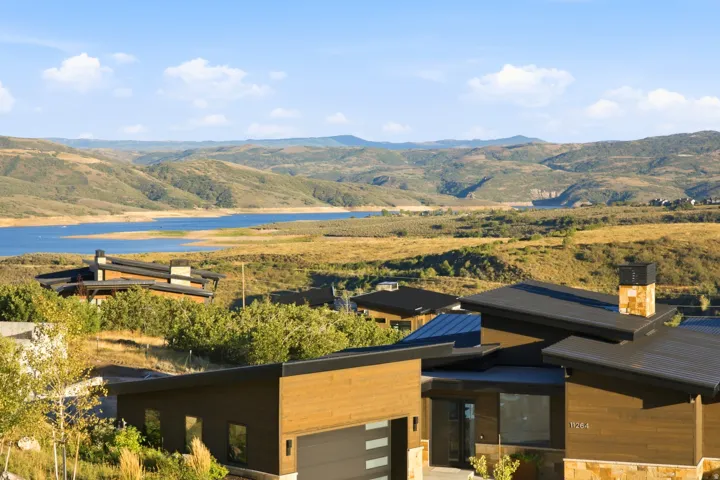 Modern architectural design featuring sloped dark roofs, wood-finish siding, and stone accents