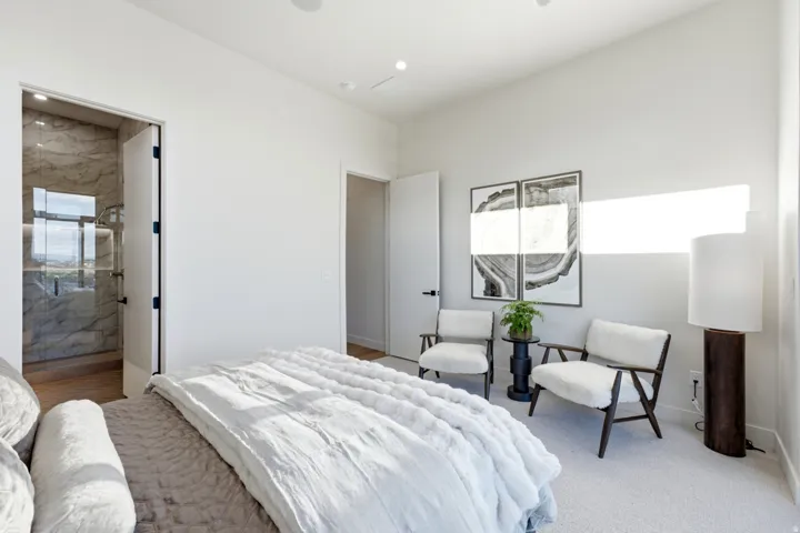 Recessed lighting, light-toned carpeting, wood-finish flooring, full-height doors, and a glass-enclosed shower with stone-look wall tiling