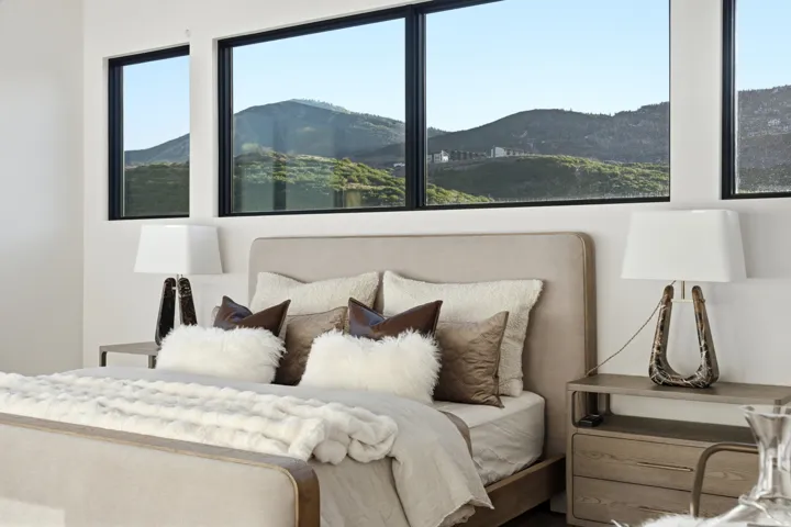 Multiple large windows frame a mountain backdrop