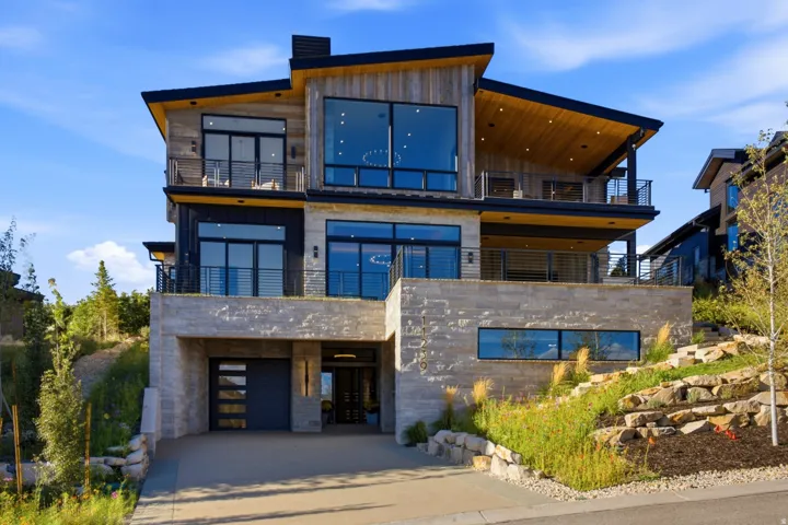 Contemporary architectural design featuring stone and wood-finish siding