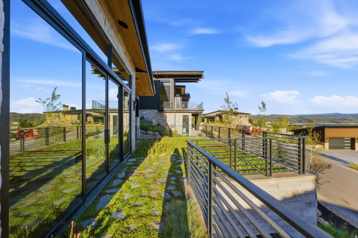 Expansive exterior featuring large format windows, a flat roofline, and stone accents