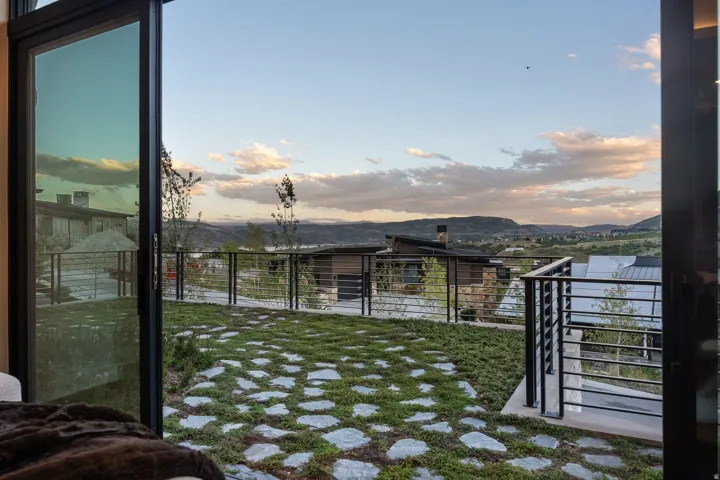 Expansive patio with stone pavers set in ground cover and cable railing