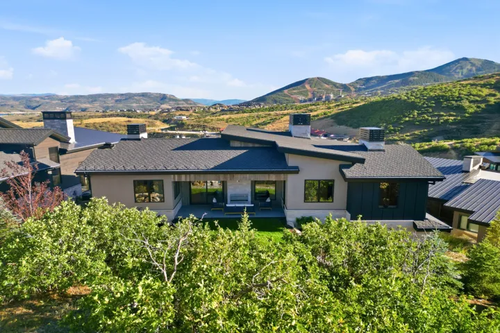 Contemporary architecture with multiple rooflines, a private patio, and expansive mountain scenery