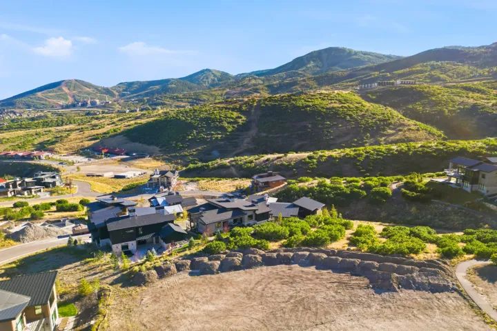 Expansive mountain landscape with surrounding natural vegetation and distant residential developments