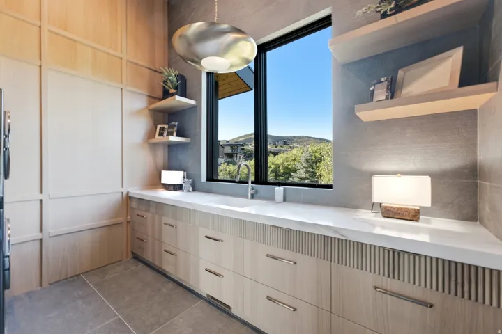 Built-in cabinetry with integrated paneling, solid surface countertops, and an undermount sink