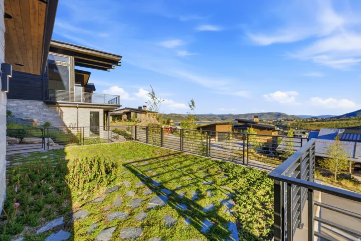 Modern exterior architecture with a flat roofline, stone siding, and wood soffits