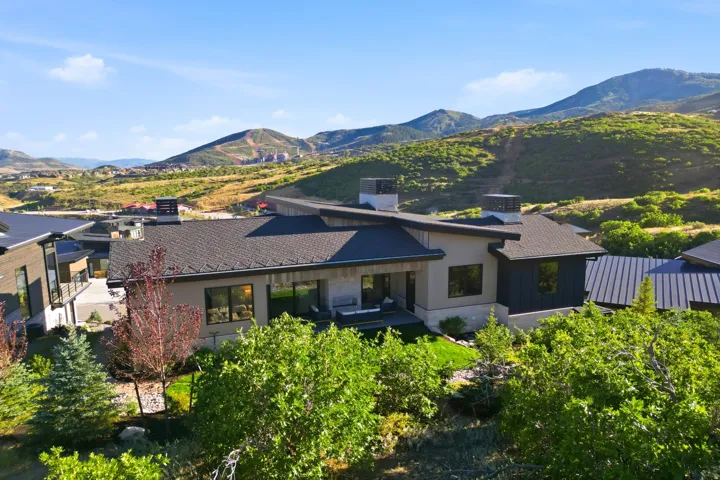 Modern exterior with a multi-level roofline, extensive window placement, and surrounding mountain scenery