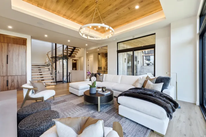 Wood-paneled ceiling with recessed lighting and a contemporary chandelier