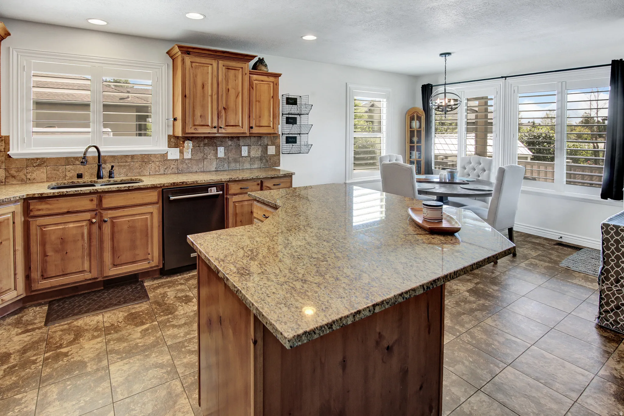 Hardwood cabinetry with stone countertops, tile backsplash, and integrated sink