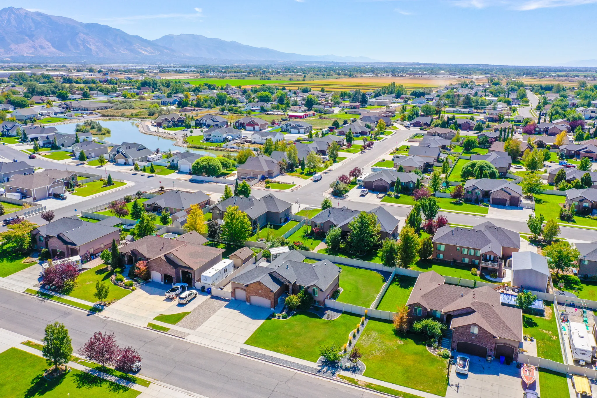 Residential neighborhood with mature landscaping, paved streets, and a prominent water feature