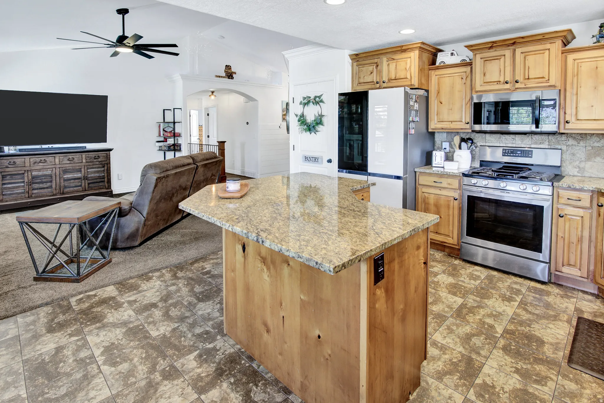 Kitchen featuring wood cabinetry, stainless steel appliances, and stone countertops