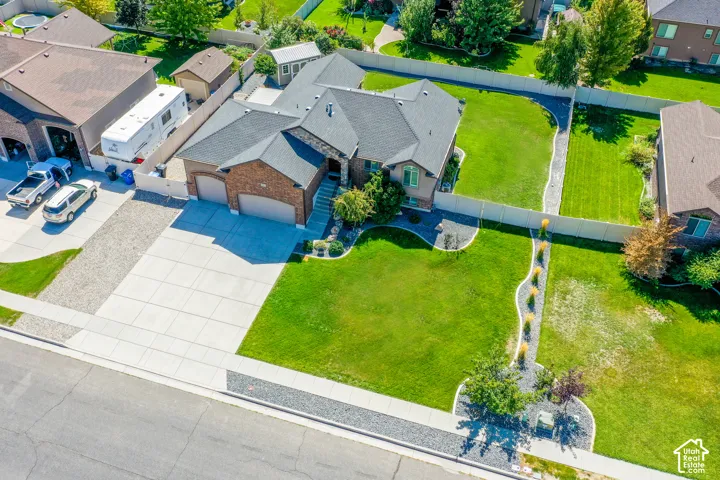 Brick exterior, attached two-car garage, mature landscaping, concrete driveway, and a fenced rear yard