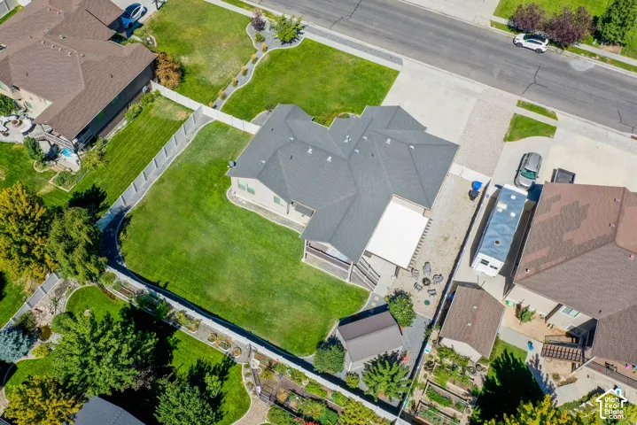 Expansive property featuring a well-maintained lawn, privacy fencing, and multiple mature trees