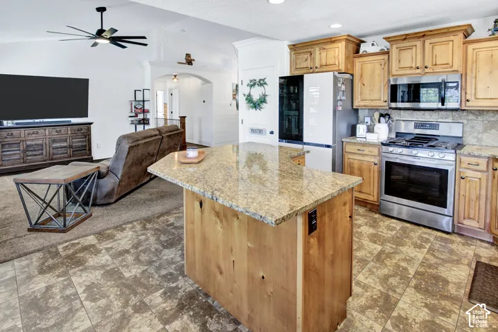 Kitchen featuring wood cabinetry, stainless steel appliances, and stone countertops