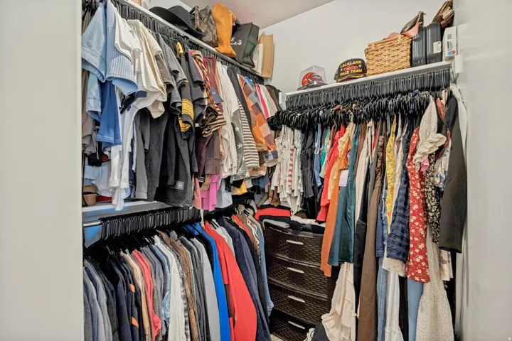 Built-in closet organization system with multiple hanging rods and integrated shelving