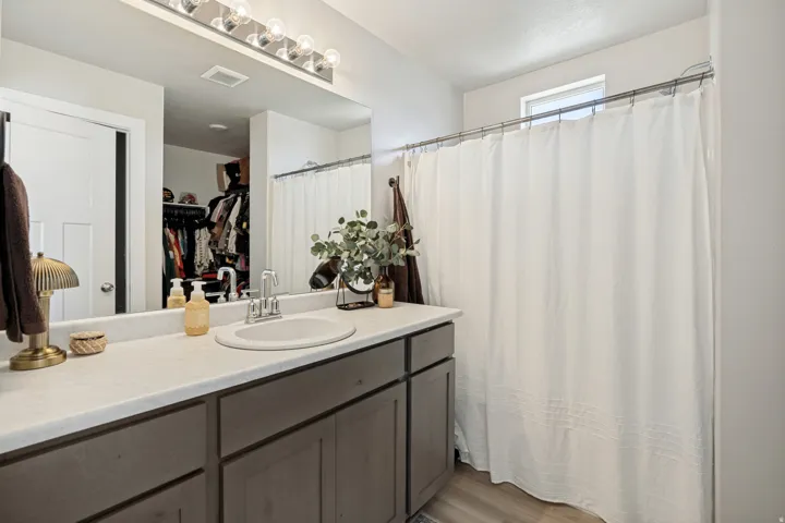 Single vanity with an integrated sink, polished chrome faucet, and gray cabinetry