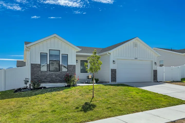 Contemporary white siding exterior with dark stone accents