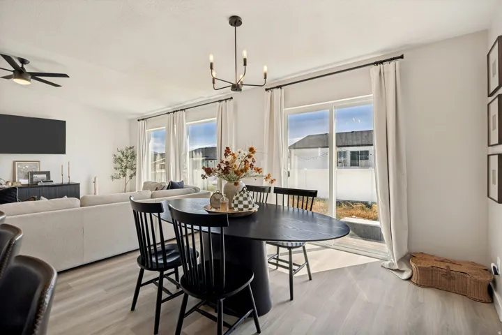 Open-concept living area with light wood-finish flooring, recessed lighting, and a contemporary ceiling fan