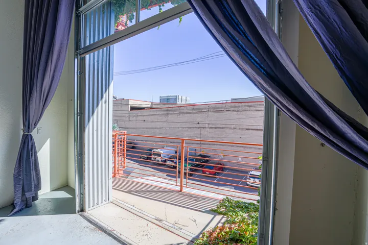 Corrugated metal door frame with an exterior metal railing and concrete flooring