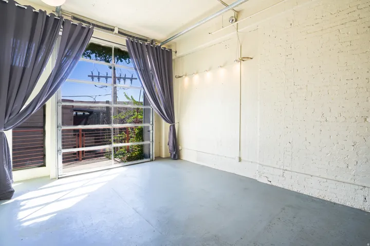 Polished concrete flooring, exposed brick wall, track lighting, and a full-glass garage door
