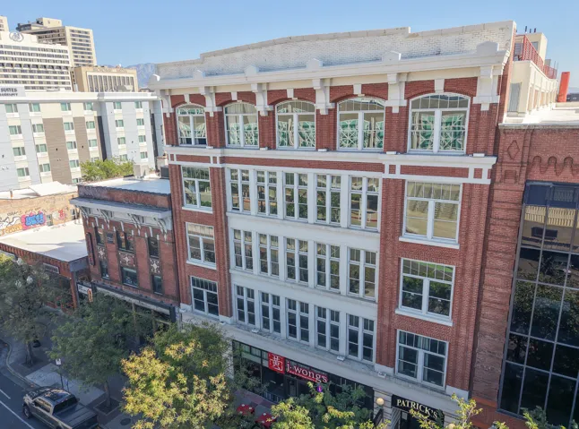 Red brick exterior featuring white architectural detailing, arched windows, and multiple levels of large pane windows
