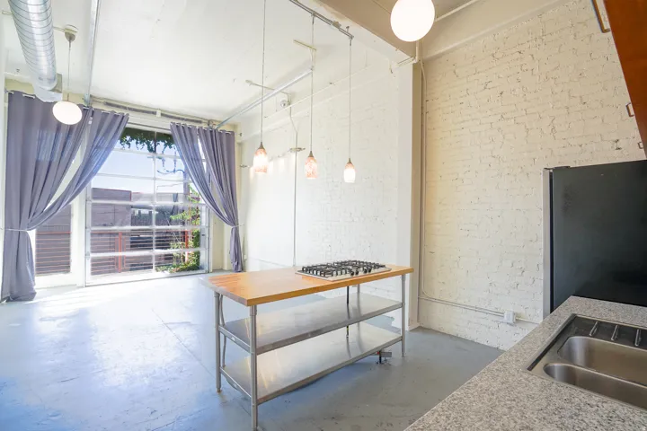 Industrial-style interior featuring exposed brick walls, a roll-up glass panel door, and concrete flooring