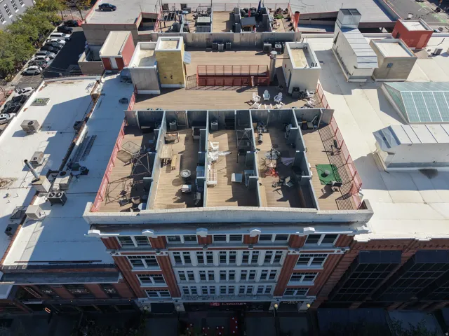 Rooftop deck featuring hardscaping, red fencing, and multiple defined lounge areas