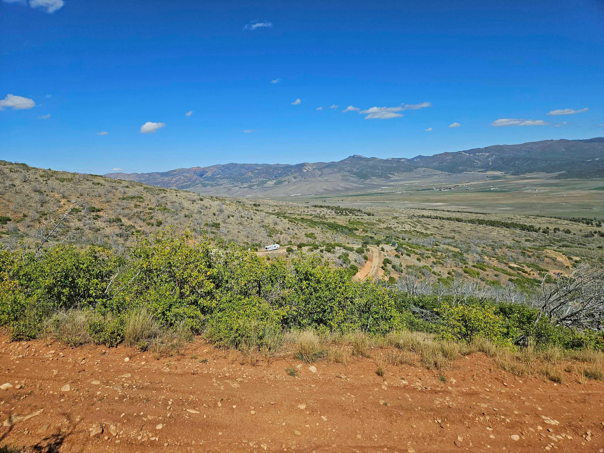 Expansive natural landscape featuring distant mountains and a blue sky
