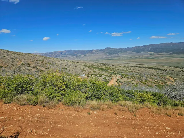 Expansive natural landscape featuring distant mountains and a blue sky
