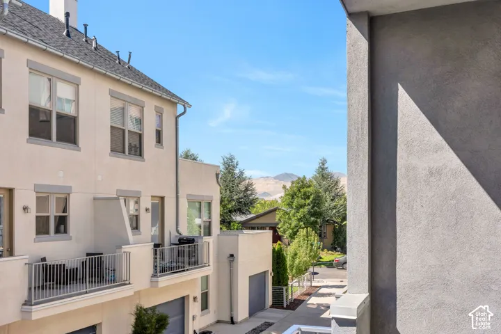 Multi-level exterior with balconies, stucco siding, and a paved driveway