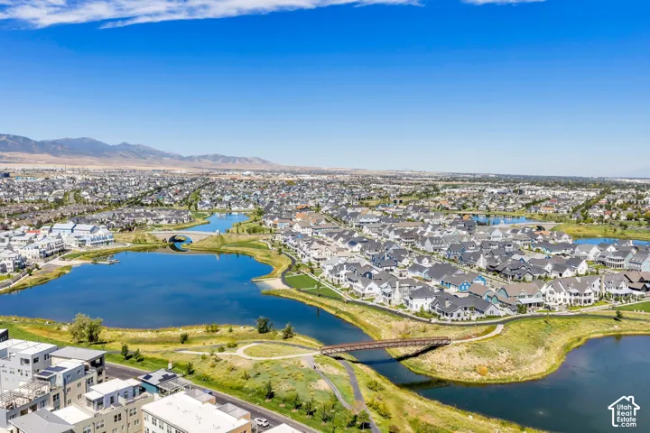Expansive community featuring multiple lakes, surrounding residential properties, walking paths, and distant mountain ranges
