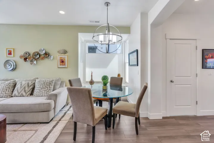 Recessed ceiling lighting, wood-finish flooring, and a contemporary chandelier