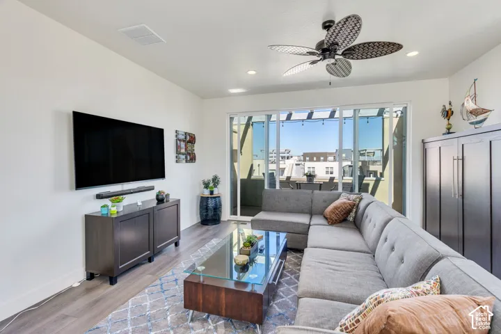 Recessed lighting, wood-finish flooring, ceiling fan, sliding glass door, and built-in storage cabinet