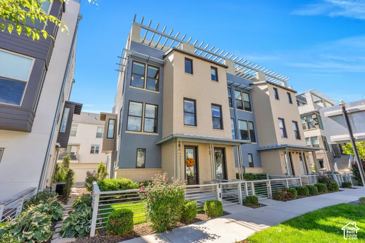 Contemporary multi-story exterior with a mixed material facade and decorative rooftop pergolas