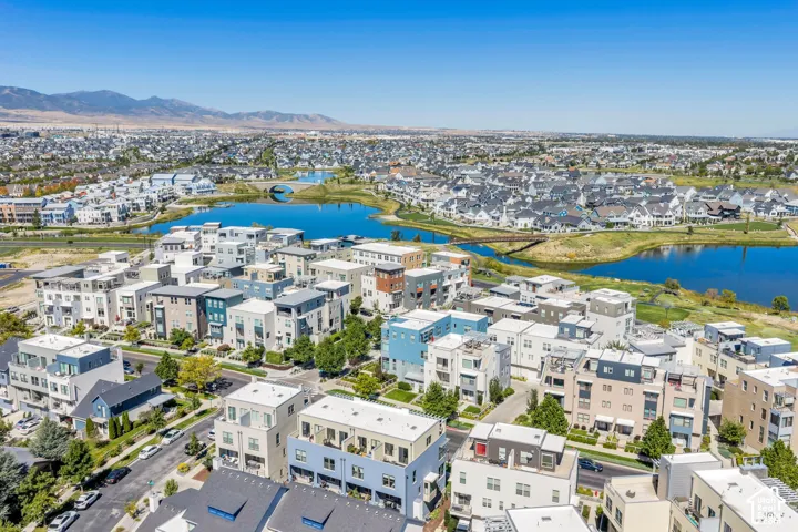 Aerial perspective showcasing a community with varied architectural styles, a prominent body of water, and surrounding development