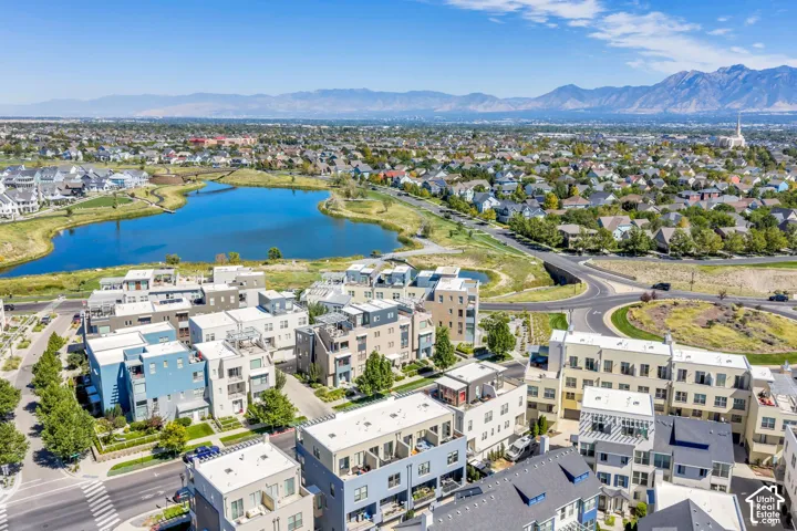 Modern townhomes featuring multiple levels, private balconies, and proximity to a large water feature and open green spaces