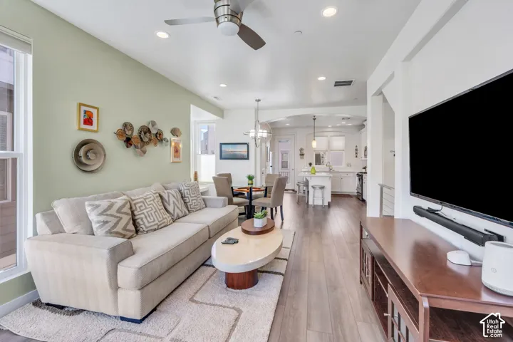 Open-concept living space featuring wood-finish flooring, recessed lighting, and a ceiling fan