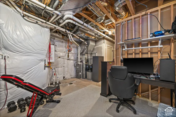 Unfinished basement space with exposed structural beams and utilities