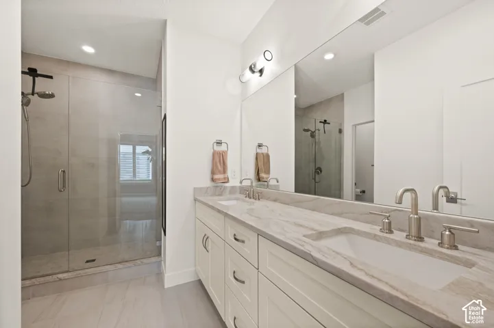 Ensuite primary bath features double vanity with undermount sinks, brushed nickel faucets, and a granite countertop. Toilet room to the left