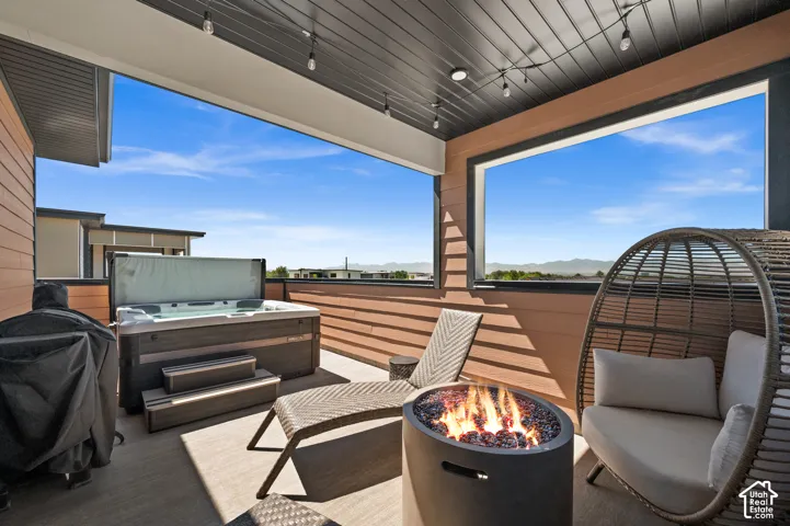 Expansive outdoor deck featuring a hot tub, fire pit, and durable composite decking