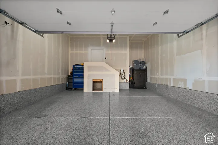 Epoxy-coated flooring extending up the walls, extra tall garage for future overheads storage, overhead garage door track system, and built-in overhead lighting