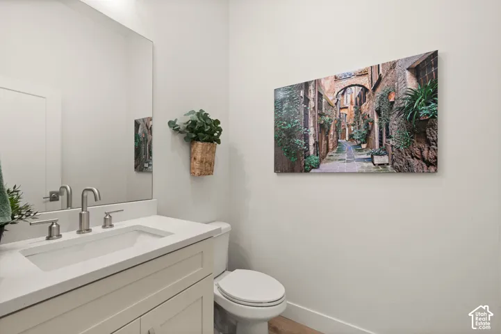 Powder bathroom with white vanity with a rectangular undermount sink and a large wall-mounted mirror