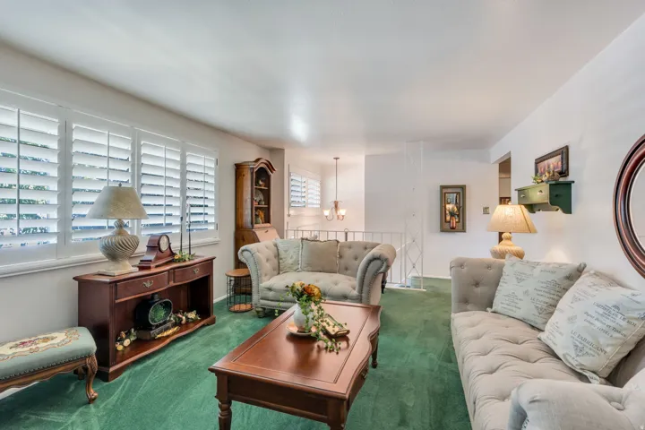 Bright living area featuring white plantation shutters and light-colored walls